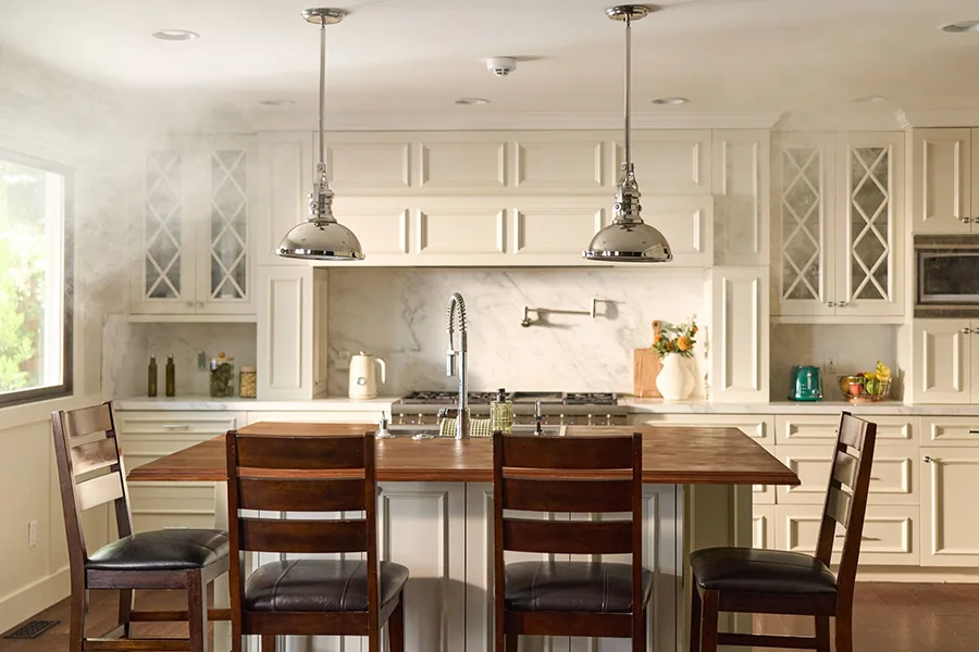Monitored fire alarms can prevent major damage if an emergency occurs when you're away. Vivint Smoke & CO detector attached to the ceiling in a kitchen and dining area